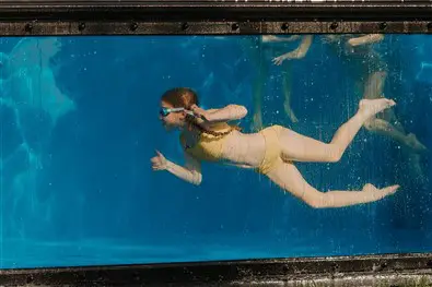 A girls taking a dive on a pool
