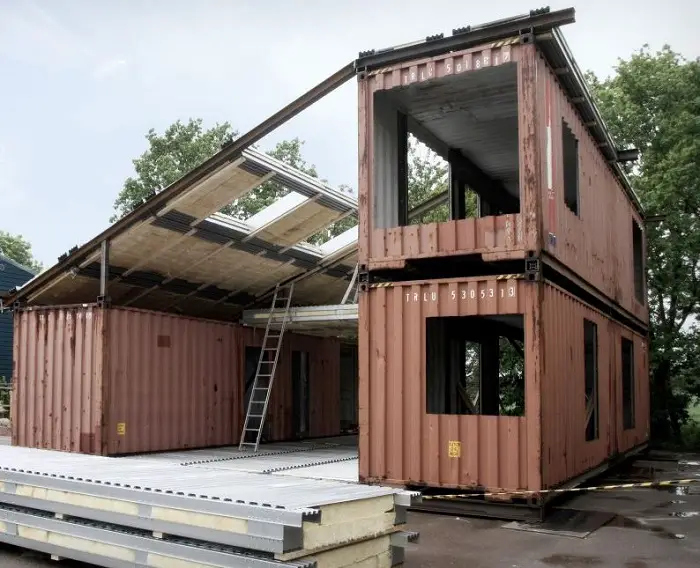 A sea container house being reinforced for stability