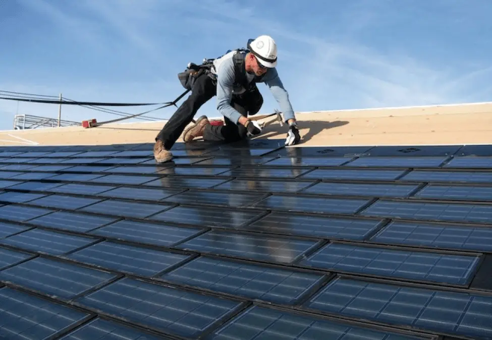 solar lease vs solar financing. A man installing Solar shingles