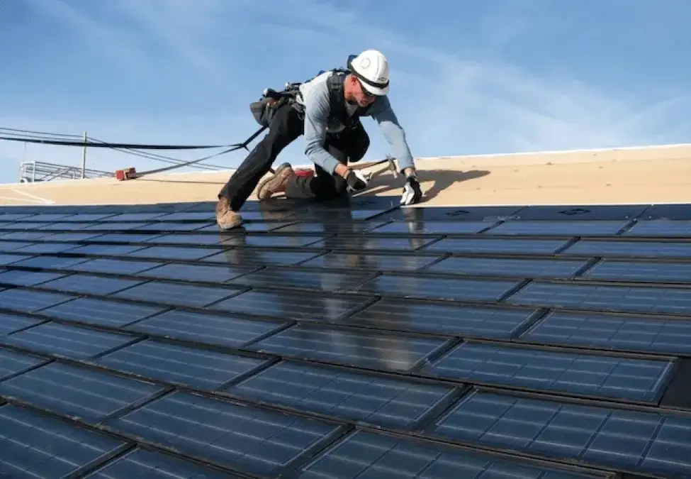 solar lease vs solar financing. A man installing Solar shingles
