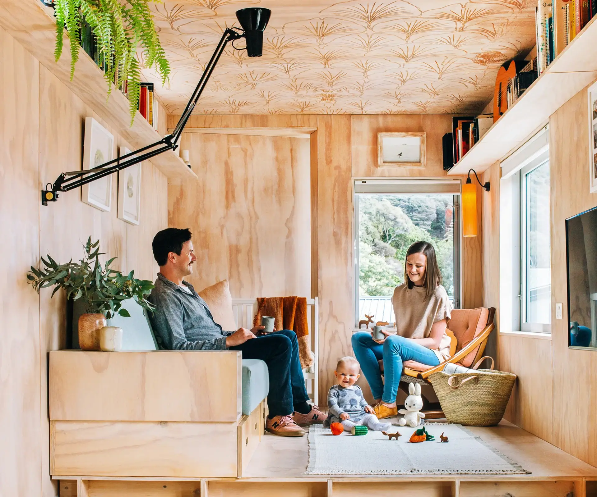 A man in a container home with his wife and daughter having some good time