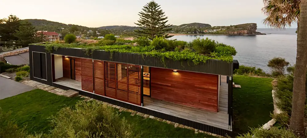 A container home covered with a beautiful green roof