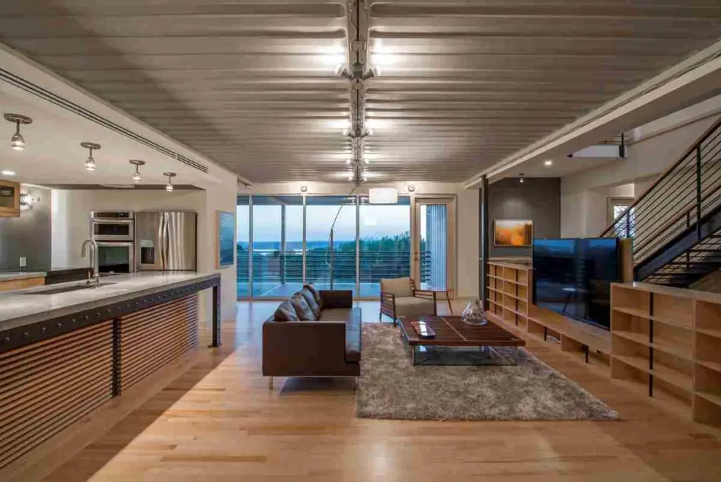 Kitchen and living area of luxurious intermodal container home from PV14 House by M Gooden Design